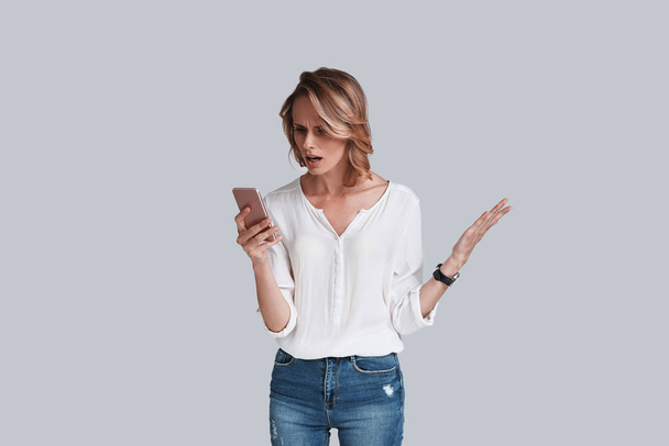 Shocked woman with smart phone - Foto, afbeelding