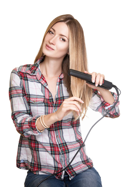 woman using hair straightener - Фото, изображение