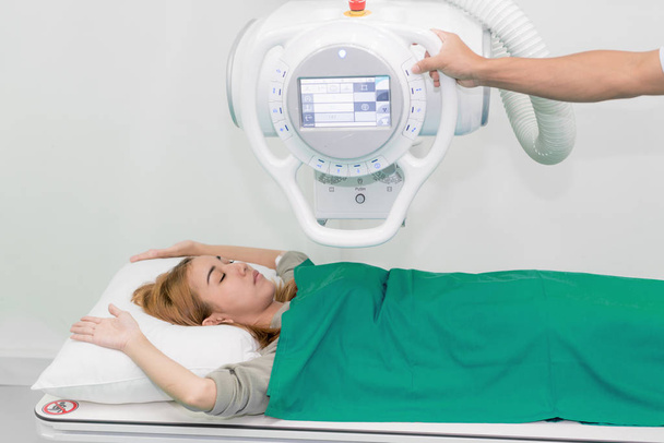 Asiatico giovane paziente donna sdraiato sotto dispositivo a raggi X con radiolog
 - Foto, immagini