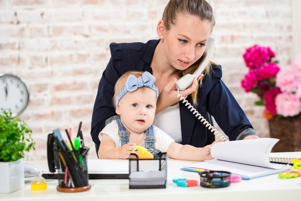 Family Business - telecommute Businesswoman and mother with kid is making a phone call - Photo, Image