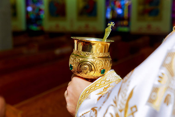 奉献式の間に聖餐杯カップとカトリックの司祭 - 写真・画像