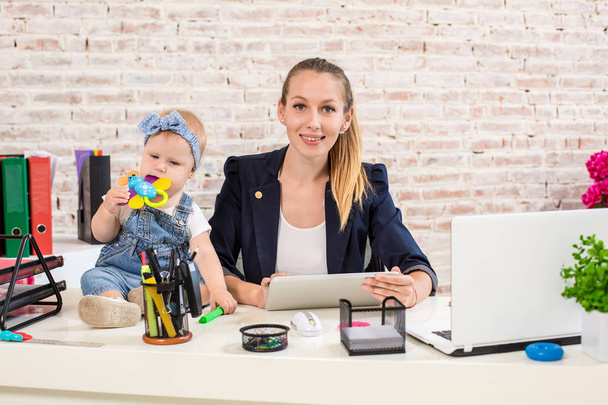 Mamá y mujer de negocios que trabajan con el ordenador portátil en casa y jugando con su niña
. - Foto, Imagen