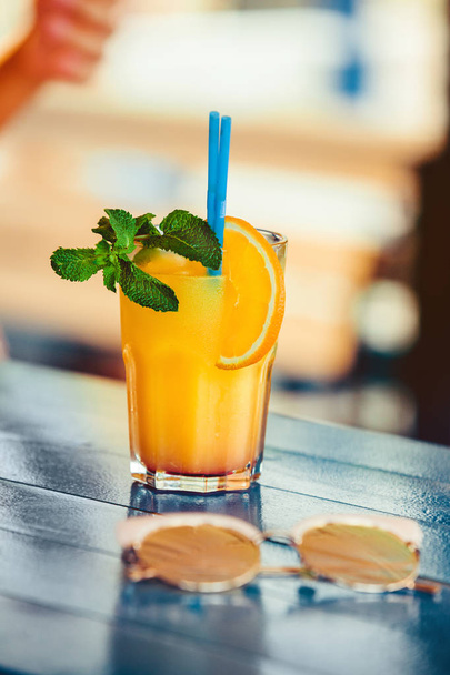 Cocktail in Frauenhand auf der offenen Terrasse in der Bar im Sommer - Foto, Bild
