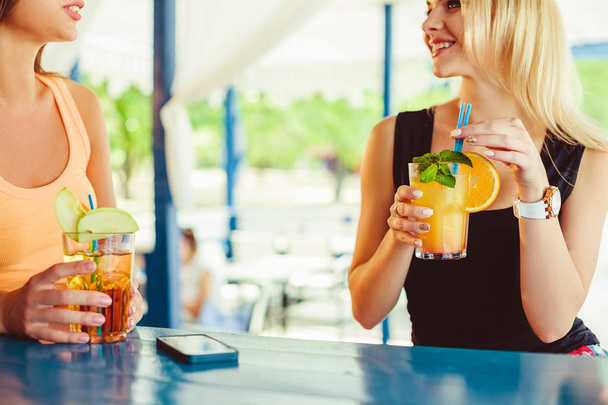 Cocktail naisen kädessä avoimella terassilla baarissa kesäaikaan
 - Valokuva, kuva