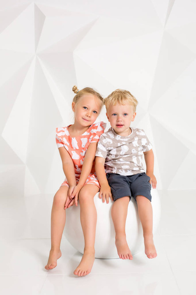 Πορτρέτο της η αδελφή και το μικρό του αδελφάκι στο λευκό στούντιο - Φωτογραφία, εικόνα