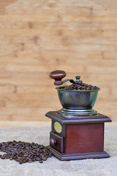 Kaffeemühle voller gerösteter Kaffeebohnen und Kaffeekügelchen - Foto, Bild