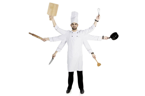 Italský šéfkuchař drží kuchyňské náčiní na studio - Fotografie, Obrázek