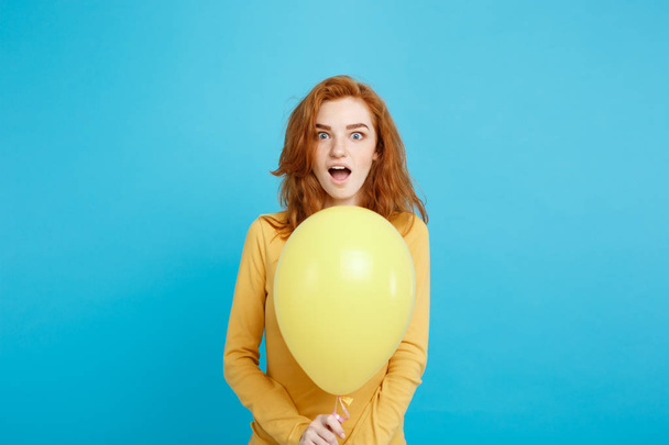 Close up Portrait happy young beautiful attractive redhair girl smiling with colorful party balloon. Blue Pastel Background. - Photo, image