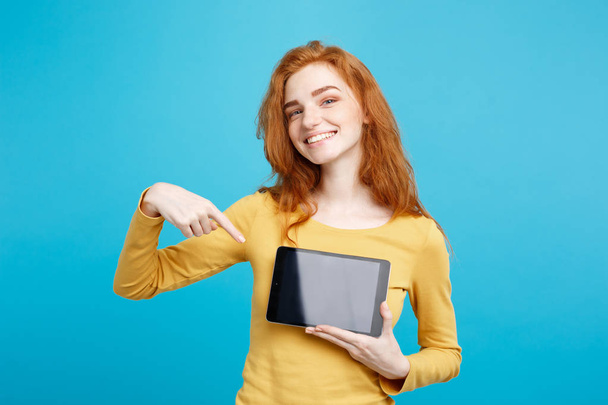 Close up Portrait young beautiful attractive redhair girl smiling showing digital tablet screen on black. Blue Pastel Background. Copy space. - Foto, Imagem