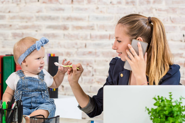 Empresa familiar - teletrabajo Empresaria y madre con el niño está haciendo una llamada telefónica
 - Foto, imagen