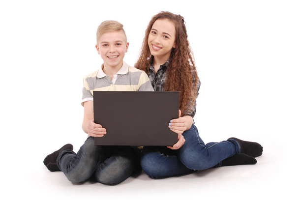 Boy and girl using a laptop isolated - Foto, afbeelding