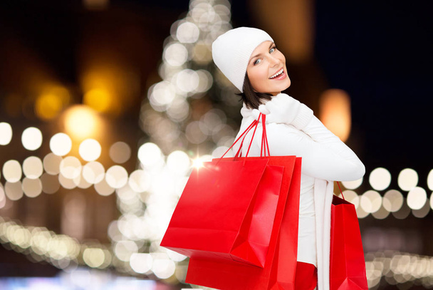 happy woman with shopping bags over christmas tree - Photo, Image