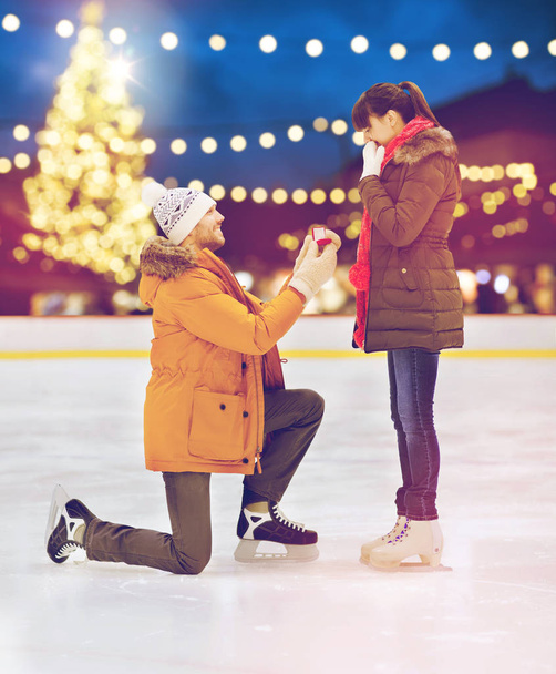 couple with engagement ring at xmas skating rink - Photo, Image