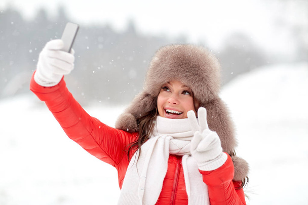 happy woman taking selfie outdoors in winter - Photo, Image