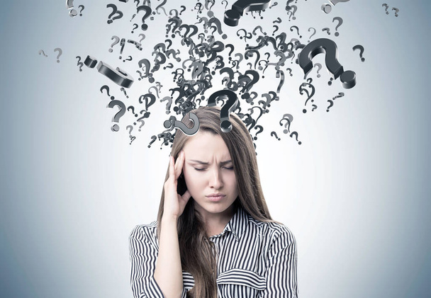 Stressed woman in a shirt, question marks - Photo, Image