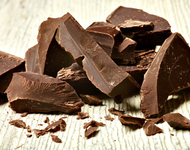 zbliżenie kawałków czekolady na drewnianym tle - Zdjęcie, obraz