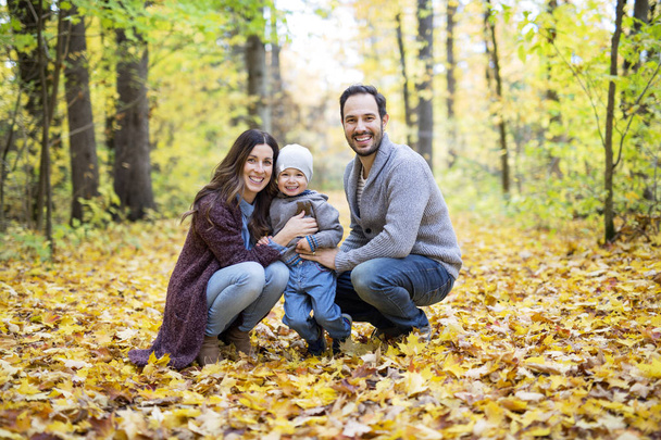 Happy family relaxing outdoors In autumn park - Фото, зображення