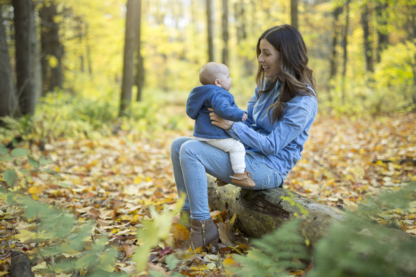 Mother with daughter baby in autumn forest - Fotografie, Obrázek