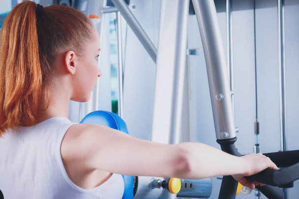 Beautiful girl at the gym exercising on trainers. Beautiful girl - Fotoğraf, Görsel