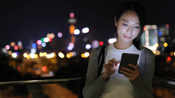 Femme envoyant des SMS sur téléphone portable la nuit
  - Photo, image