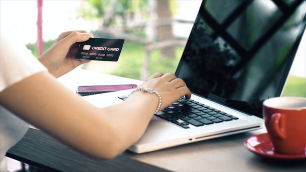 Detrás de la mujer joven escribiendo en el ordenador portátil y tarjeta de crédito para ir de compras
 - Foto, Imagen