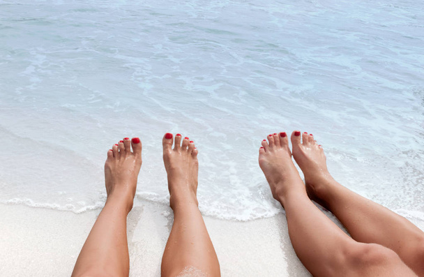 Vacation on the beach, feet on seashore - Foto, afbeelding
