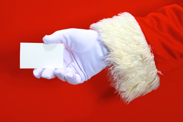 Санта-Клауса рука представлення Різдва текст або продукту на червоному тлі копію простір - Фото, зображення