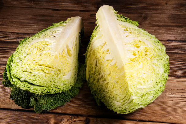 Savoy cabbage on wooden table - Фото, изображение