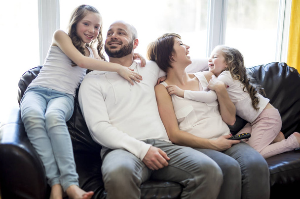 Οικογένεια κάθεται στο σαλόνι βλέποντας τηλεόραση - Φωτογραφία, εικόνα