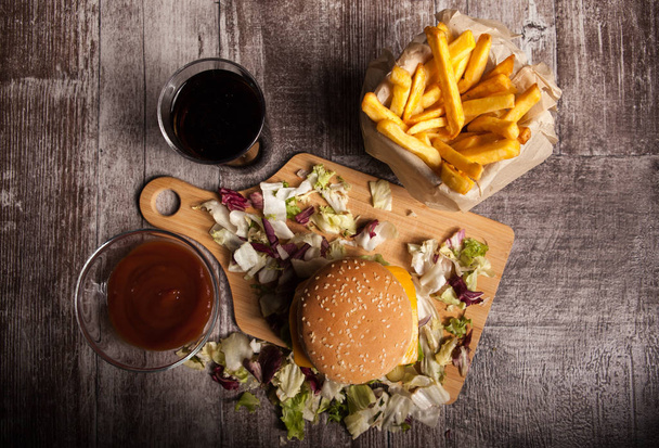 Ahşap arka plan üzerinde lezzetli lezzetli hamburger - Fotoğraf, Görsel