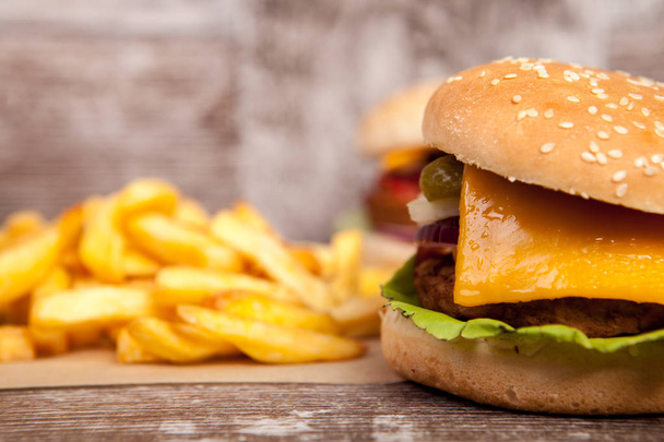 Delicious tasty burgers on wooden background - Foto, Imagen