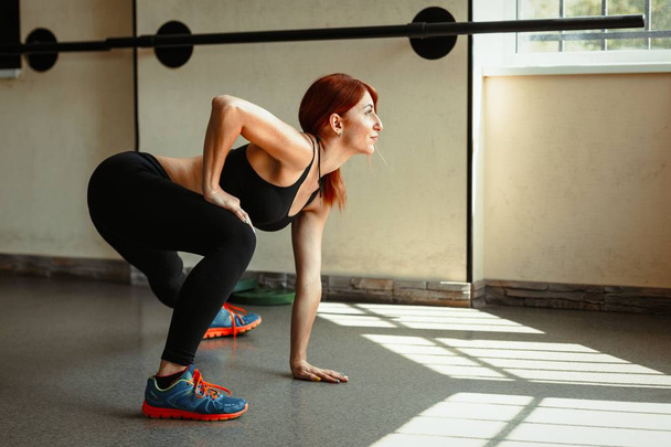 woman stretching her legs in gym - Fotoğraf, Görsel