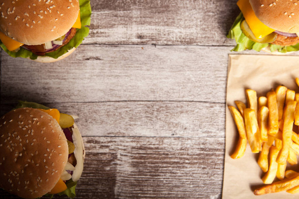 Delicious tasty burgers on wooden background - Photo, Image