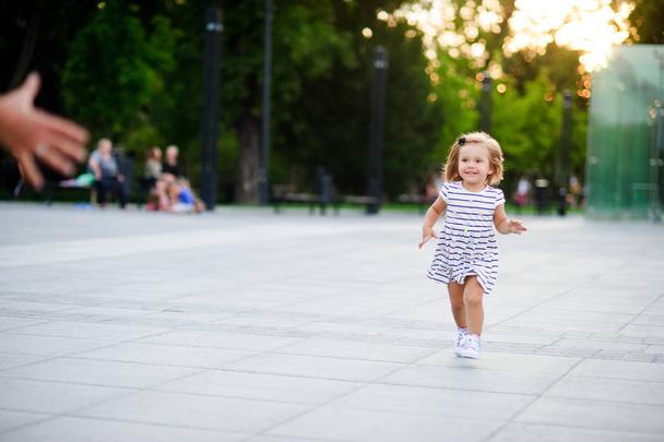 Rozkošná holčička běží směrem k nadřazené ruce. - Fotografie, Obrázek