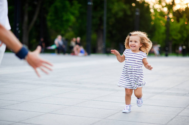 Rozkošná holčička běží směrem k nadřazené ruce. - Fotografie, Obrázek