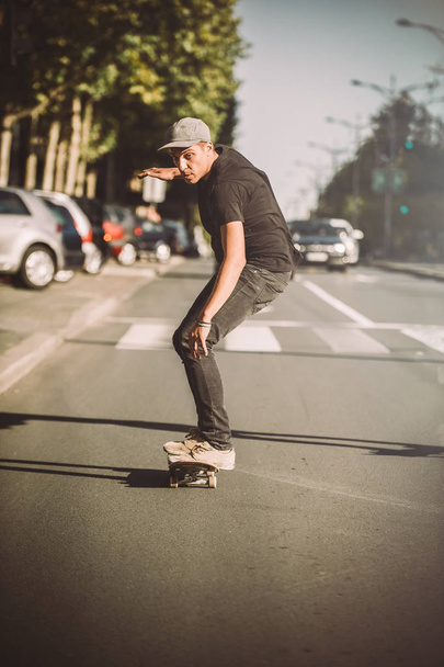 Pro skateboarder ride skateboard on capital road street through  - Fotoğraf, Görsel