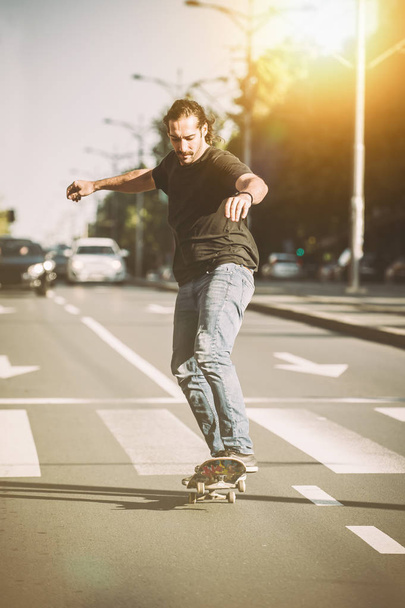 Pro skateboarder ride skateboard on capital road street through  - Foto, imagen