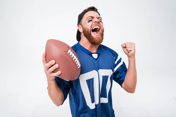 Excited screaming man fan holding rugby ball. - Фото, зображення
