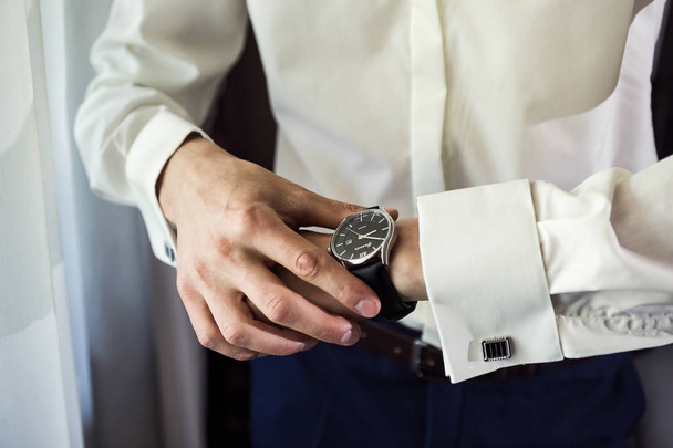 бізнесмен годинник одяг, бізнесмен перевіряє час на своєму крилі
 - Фото, зображення