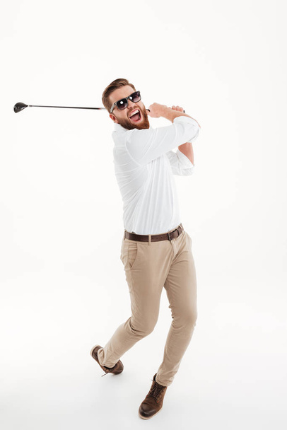 Young screaming emotional bearded man holding golfstick - 写真・画像