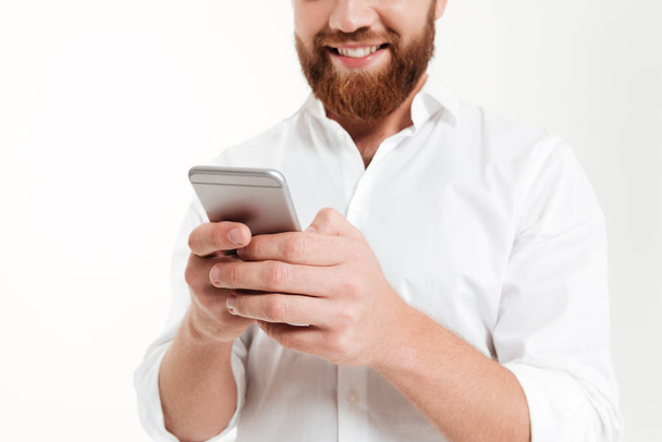 Cropped image of young bearded man chatting by phone. - Φωτογραφία, εικόνα