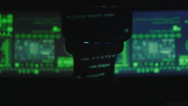 ハッカー プログラマーのシルエットは、彼の顔に緑のコード文字を反映しながらプログラミングの仮想現実ヘルメットを使用します。それ未来の技術. - 映像、動画