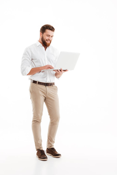 Handsome young bearded man using laptop. - Photo, Image