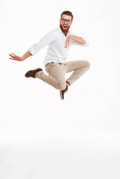 Cheerful young bearded man jumping. - 写真・画像