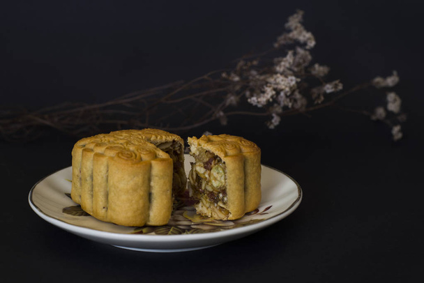 Mid Autumn Festival moon cakes with mixed nuts filling on black  - Photo, Image