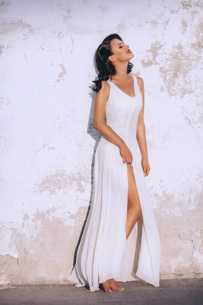 Женщина позирует в белом платье
  - Фото, изображение