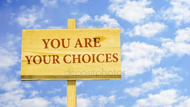 You are your choices. Words on a wooden sign against time lapse clouds in the blue sky.  - Footage, Video