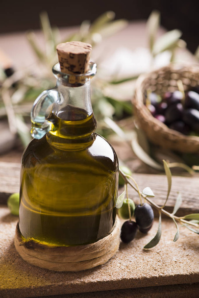 Olive oil and olives on wooden rustic table - Foto, imagen