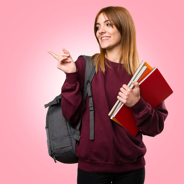 Student woman pointing to the lateral on colorful background - Photo, Image