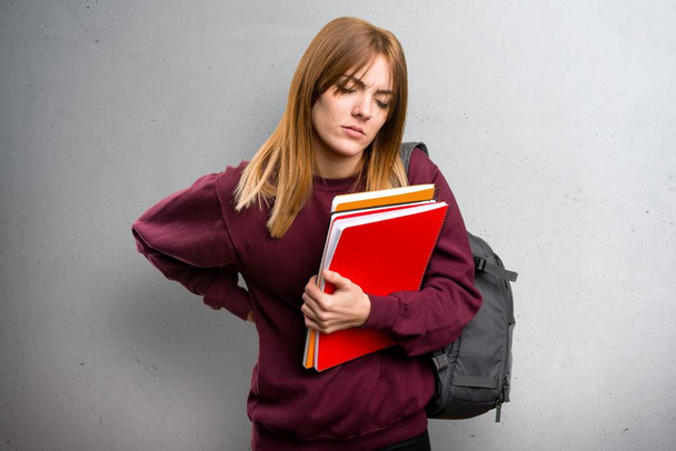 Student woman with back pain on grey background - Foto, Imagem